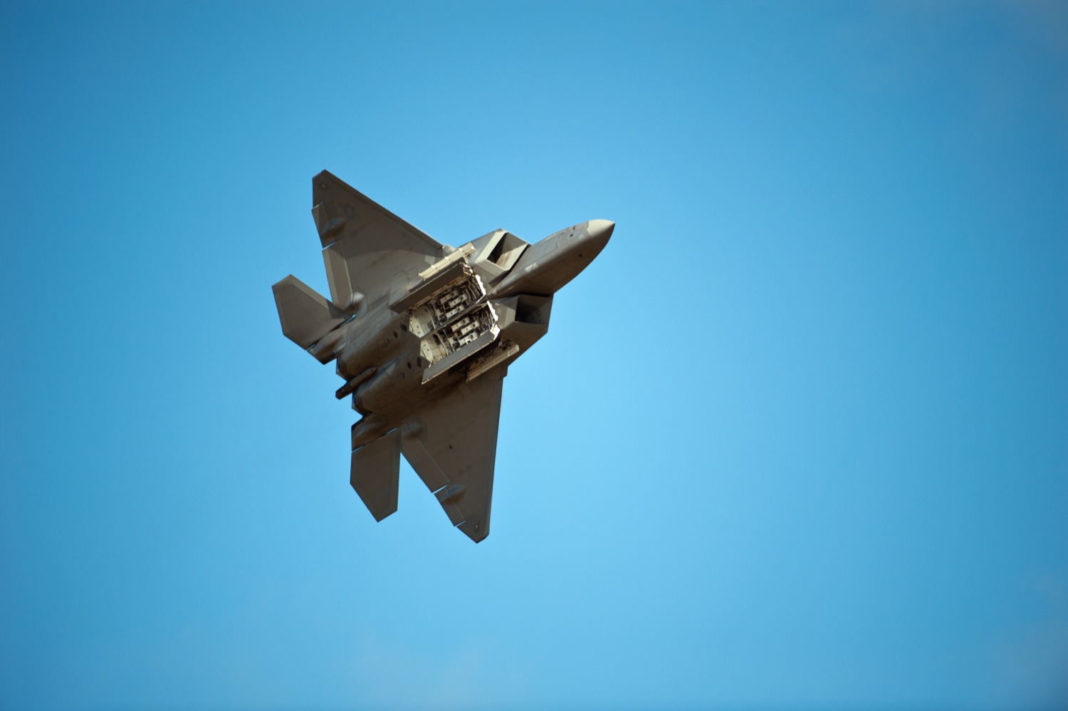 A U.S. Air Force F-22 Raptor in flight with its internal weapons bay open during a demonstration pass at the Arctic Thunder air show, Joint Base Elmendorf-Richardson, Alaska, 26 July 2014.